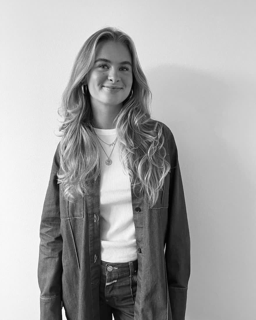Leony, Lifestyle-Creatorin aus Hamburg, im Jeanshemd vor heller Wand (Schwarz-Weiß-Porträt)
