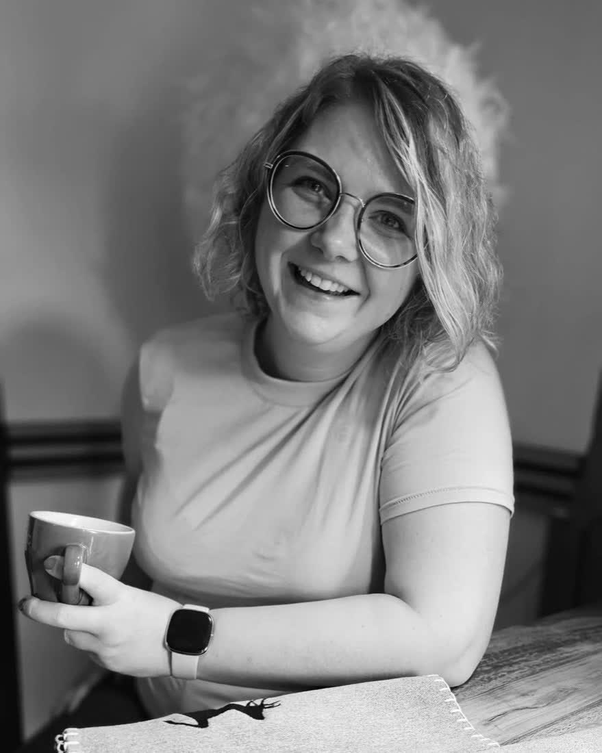 Sonja, Zwillingsmama und Creatorin, lächelt mit einer Tasse in der Hand (Schwarz-Weiß-Porträt)